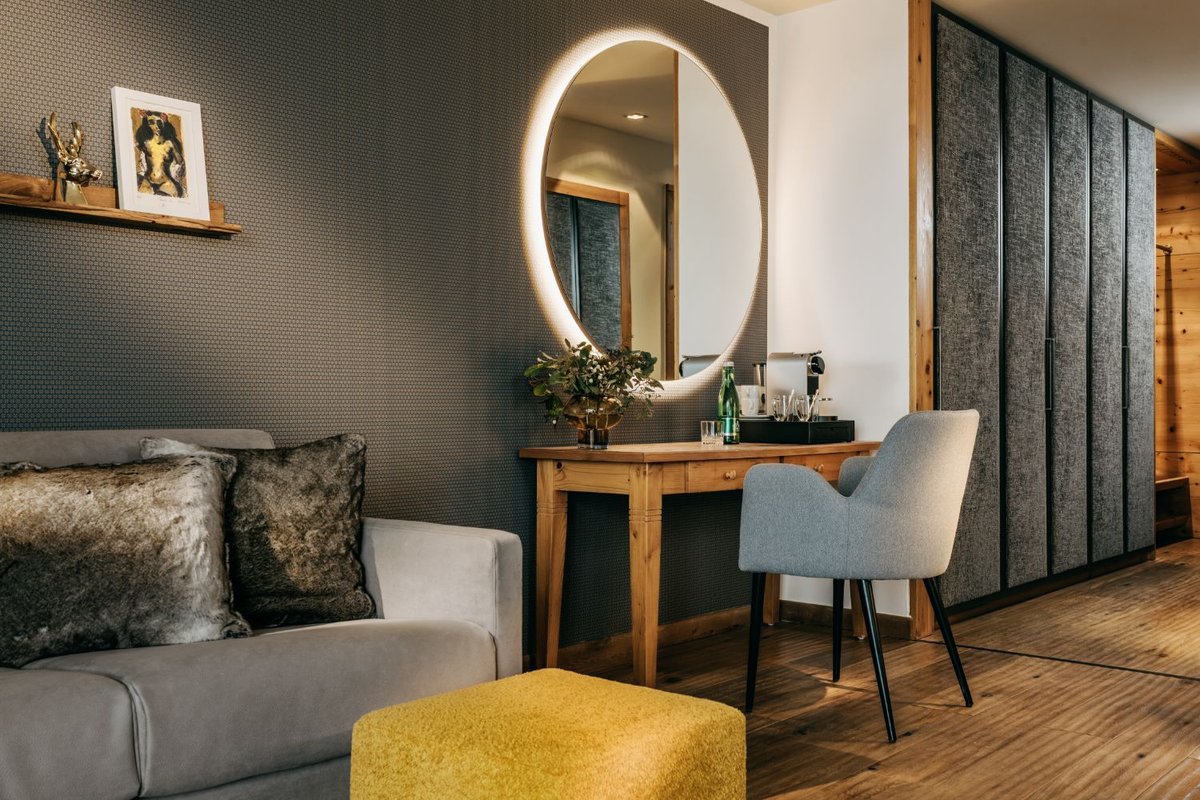 The sitting area in a suite with a desk and mirror