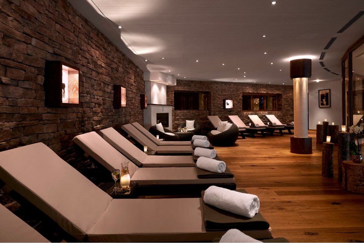 Der luxuriöse Entspannungsbereich mit Liegestühlen und Handtüchern im Wellnesshotel in Kitzbühel