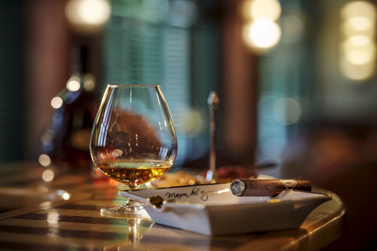 Close-up of a bourbon glass and a cigar on a table