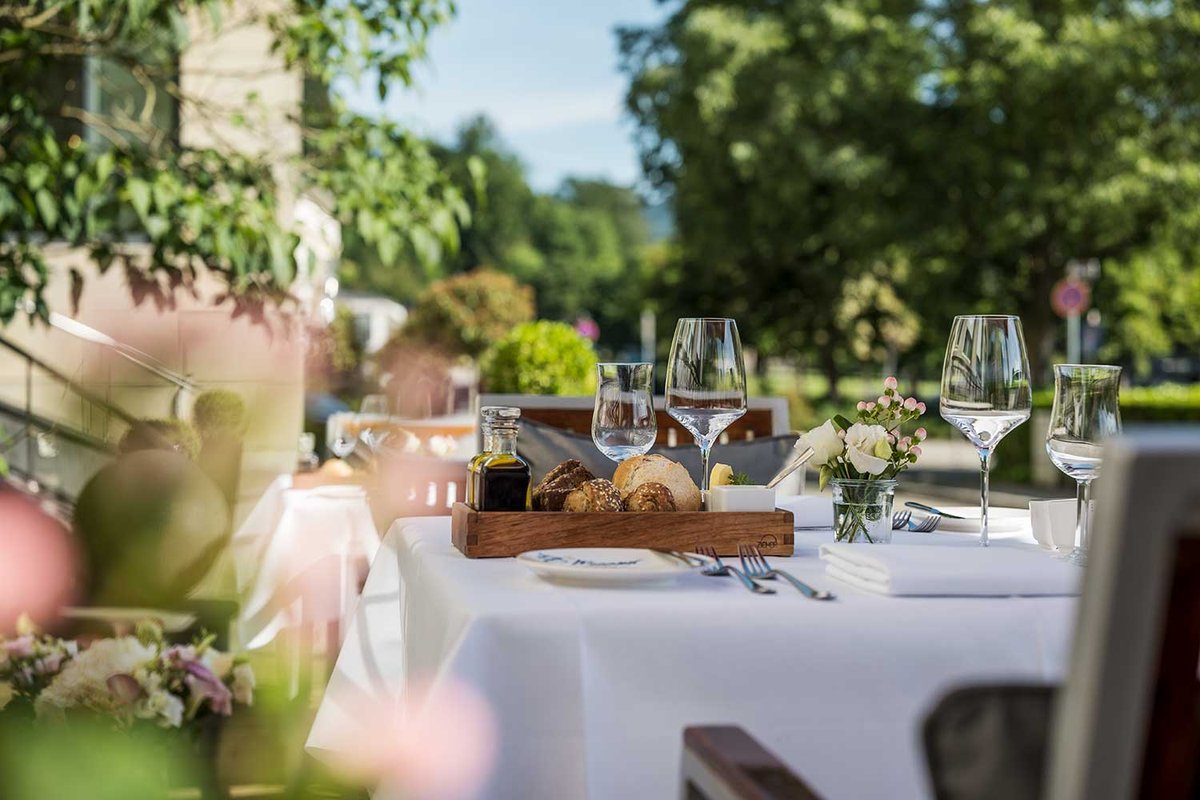 Ein gedeckter Tisch im Freien mit Weingläsern, Brot und Olivenöl