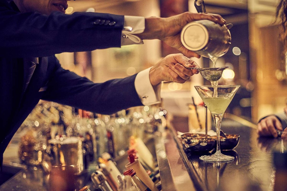 A bartender creates a yellow cocktail