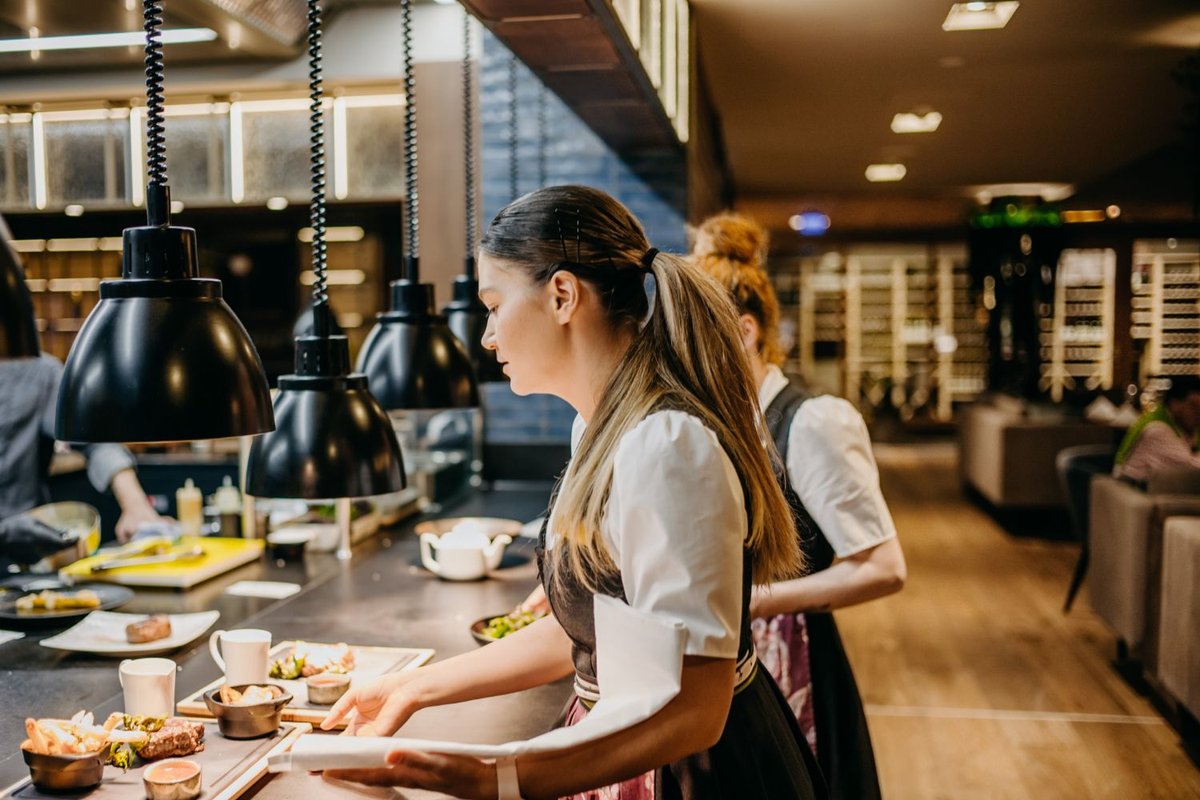 Zwei Kellnerinnen beim Abholen der Speisen aus der offenen Küche des Restaurant Tirolia