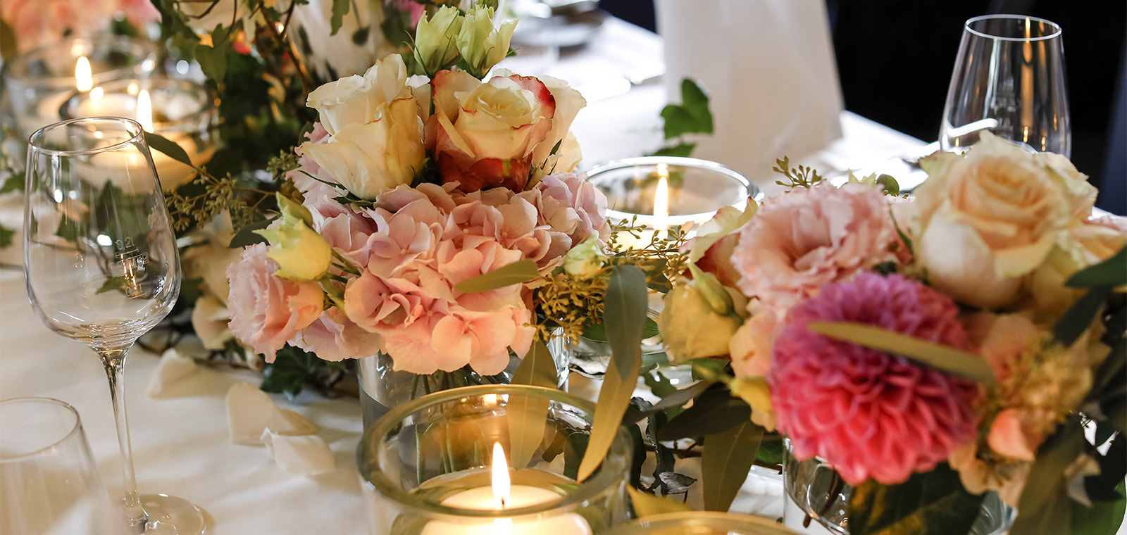Nahaufnahmen einer Tischdekoration mit Blumen, Kerzen und Weingläsern in der Nassauer Hof Hochzeitslocation Wiesbaden 