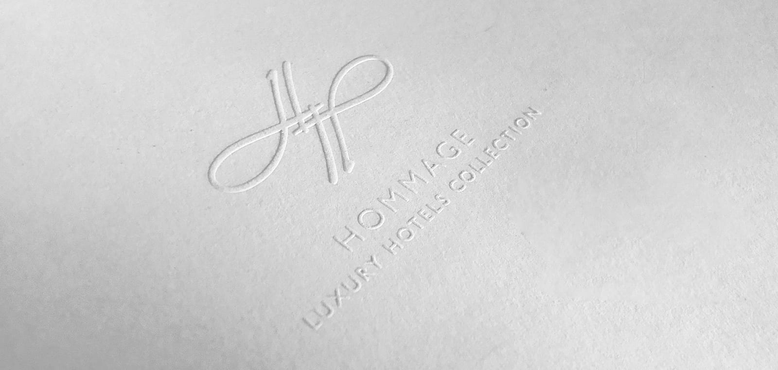 Das Logo der Hommage Hotels auf weißem Papier