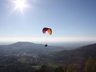 A paraglider sails in the air 