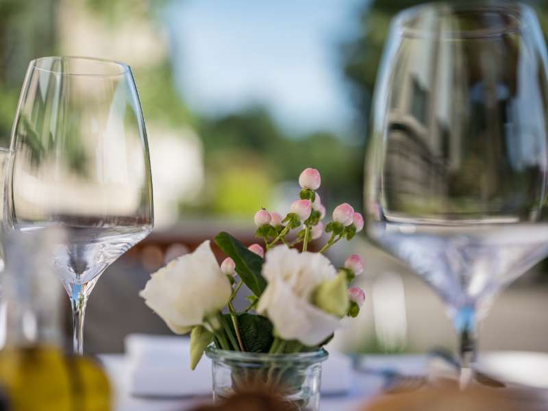 Nahaufnahme zweier Weingläser zwischen Blumendekoration in der Hochzeitslocation in Baden Baden