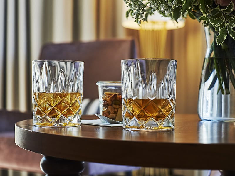 Close-up of two filled whiskey glasses on a round wooden table in the event location in Baden Baden.