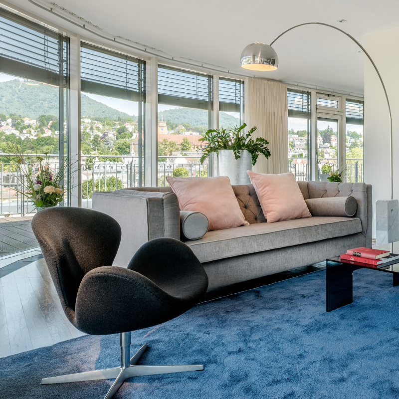 Blick auf den Wohnbereich der Penthouse Suite mit einem schicken Sofa