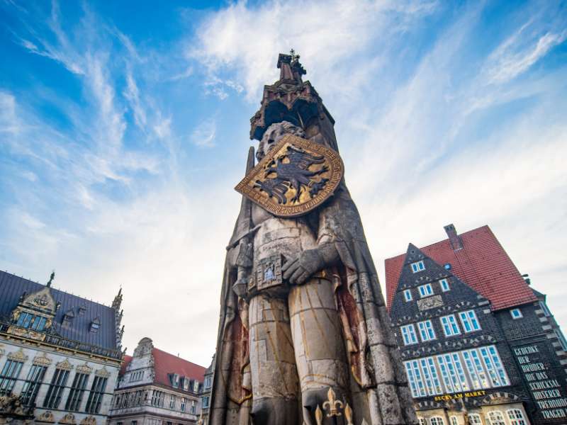 Eine hohe Skulptur mit einem Wappen darauf in der Bremer Stadt