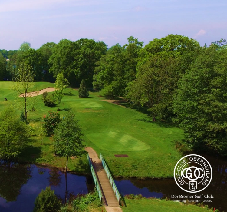 Eine Luftaufnahme eines Waldes und der dahinterliegenden Stadt mit Wegbeschreibungen zum Golfplatz