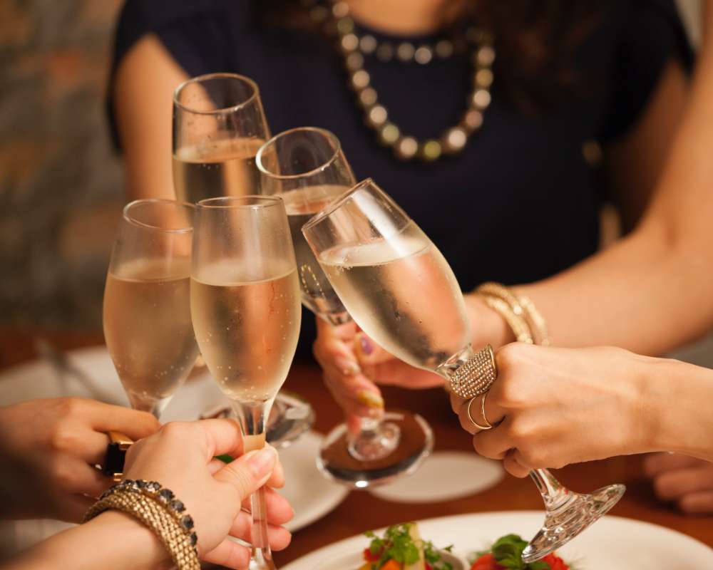 Five ladies toast together with champagne