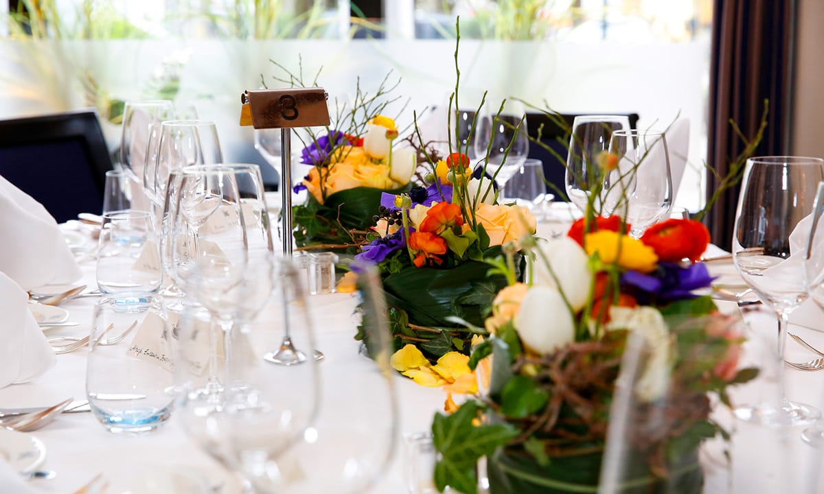 Bunte Blumenarrangements auf einem gedeckten Tisch des Sterne-Restaurants ENTE in Wiesbaden