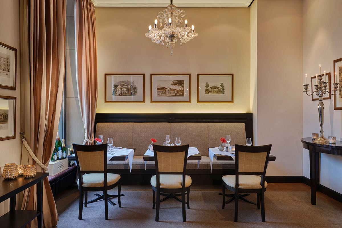 Geschmackvolles Speisezimmer mit Kronleuchter und gestreiftem Vorhang des Orangerie Restaurants im Nassauer Hof Wiesbaden