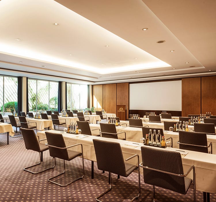 Einblick in einen schön hergerichteten Saal mit langen Tischen und vielen Stühlen in einer Eventlocation in Wiesbaden 