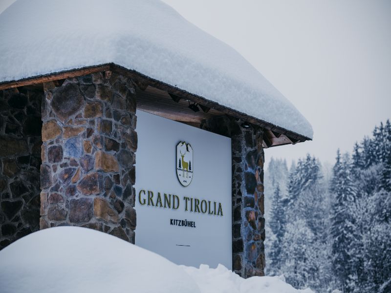 Überdachtes Eingangsschild vor dem Grand Tirolia im Winterurlaub in Kitzbühel
