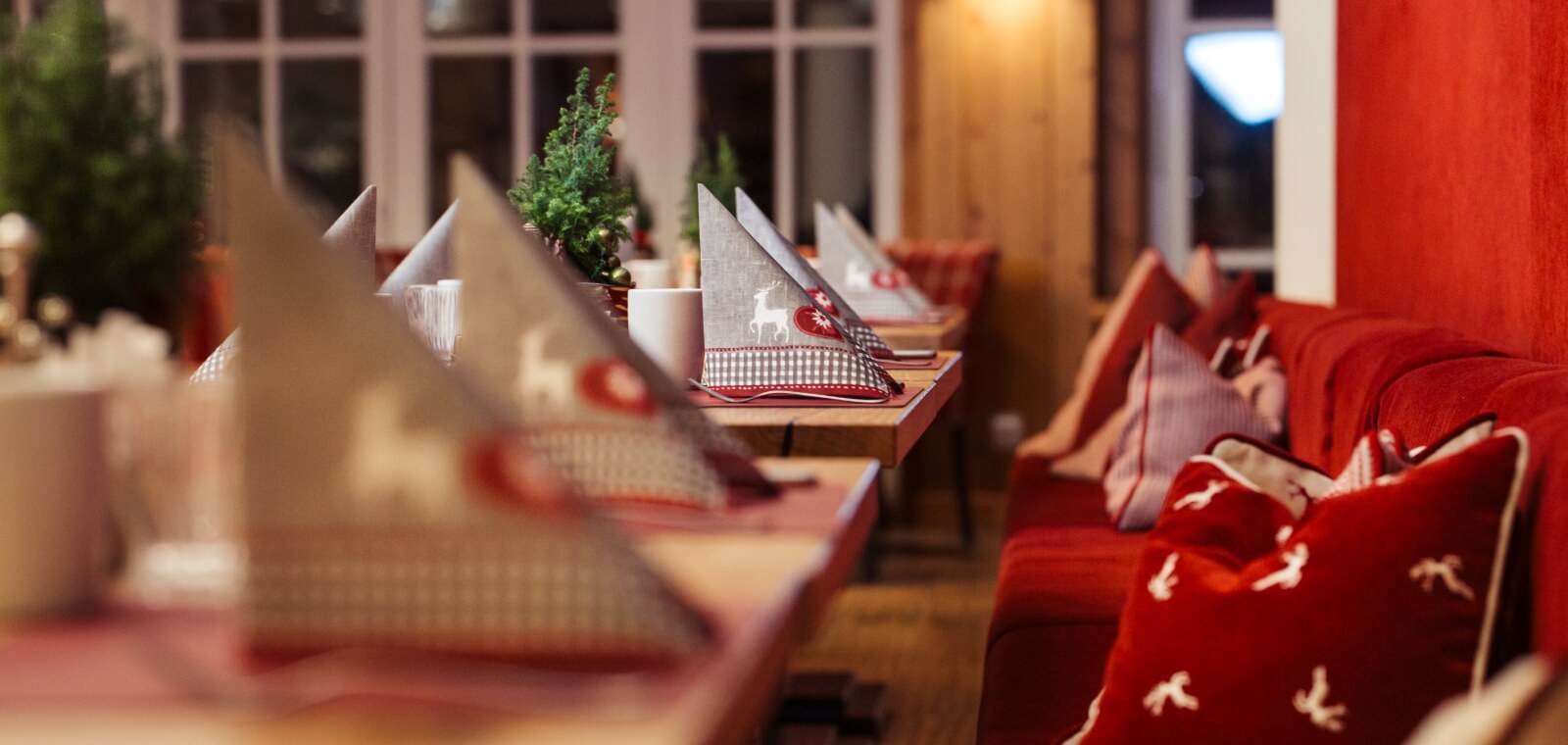 Nahaufnahme einer Bank und gedeckter Tische im Restaurant im österreichischen Genusshotel